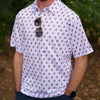 Man wearing a white polo shirt with mini Hubig's Savory Simon logos and shirt brand name DOUBLOON on left sleeve. 